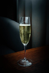 A glass of champagne, luxury bedroom interior on the background. Expensive hotel stay concept.