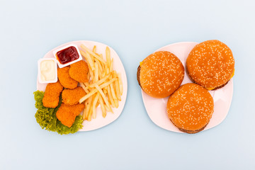 Concept of mock up burger, french fries and fried chicken set isolated on white background. Copy space for text and logo. Clipping Path included on blue background.
