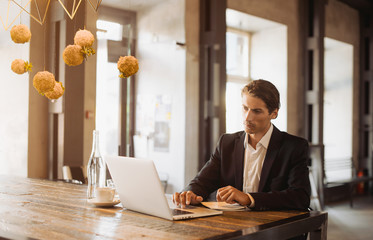 Stylish young man calling by the phone to solve business problems. Online consultation by phone. Freelancer discussing the development and planning of his online project. Outsourcing. Mobile services.