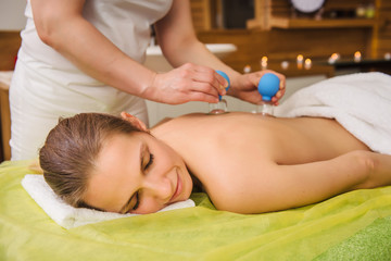 Obraz na płótnie Canvas Woman having hot jar vacuum cupping massage in spa center