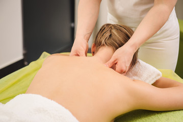 Fototapeta na wymiar Woman having neck and shoulder massage in spa center