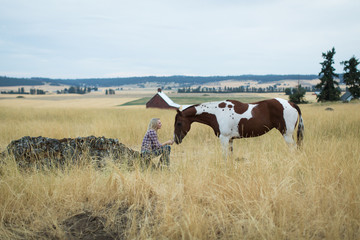 Young woman and horse in field