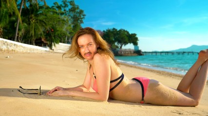 The concept of strange adventures of people. A beautiful woman in a pink bikinis on the beach,...