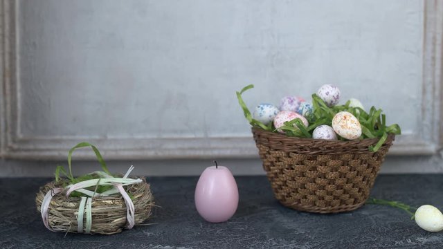 Painted ester eggs in a basket. White vintage wall in background. Copy space.