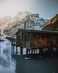 Boat hut on the frozen winter Pragser Wildsee/Lago di Braies in Italian Alps. Lake pier.