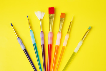 Colorful set of brush on yellow background