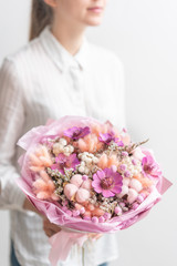 beautiful bouquet of mixed dried flowers in woman hand. the work of the florist at a flower shop. Delicate Pastel tones color
