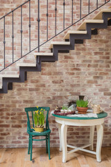 Fresh yellow daffodils potted with garden instruments on vintage chair and a table with Easter decor