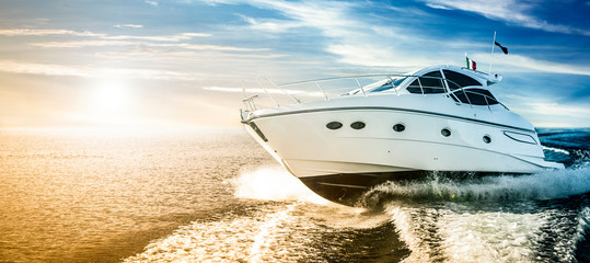 Fototapeta Luxurious motor boat sailing the sea at dawn obraz