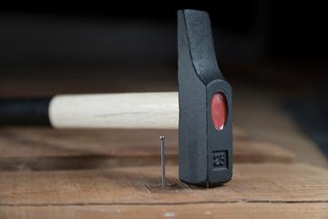 Un martillo junto con un punta de acero clavada en una madera