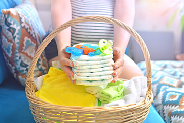Pregnant woman packing bag for maternity hospital at home. Preparing for newborn birth. Future mom...