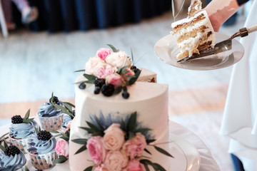 The newlyweds, the bride and groom, cut the wedding cake at the banquet.