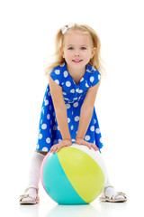 Little girl is playing with a ball