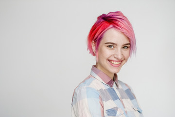 Young beautiful girl with a short hair cut pixie bob. Color hair coloring, red pink color. Shirt in...
