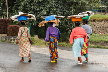 Group of Rwandan women in colorful traditionals clothes wearing washbowls on their heads, Kigali, Rwanda - obrazy, fototapety, plakaty