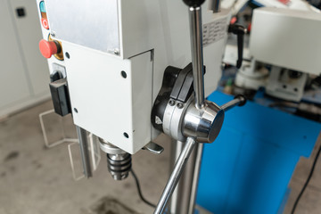 Drilling machine. New Industrial Iron drill in workshop interior. Tool store or exposition stand.