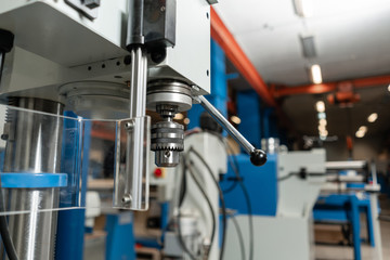 Drilling machine. New Industrial Iron drill in workshop interior. Tool store or exposition stand.