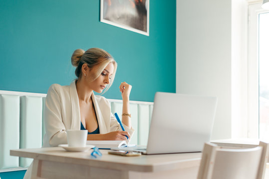 Beautiful Girl Working Out A Plan Of The Project And Concept. Girl Paints A Website Design On A Laptop. Student Prints A Message On The Phone In The Messenger. Development. Digital Marketing