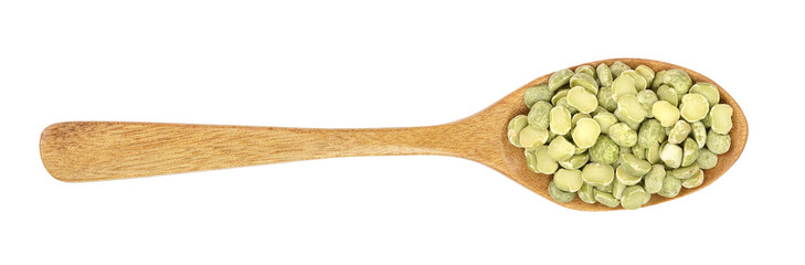 Green split peas in a wooden spoon isolated on white background. Top view