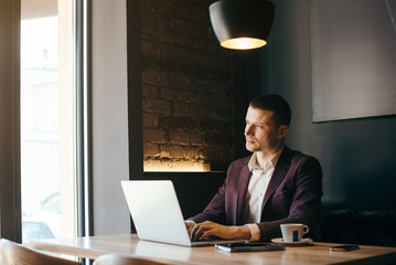 Young handsome businessman conducting negotiations with investors. Electronic business. Alternative...