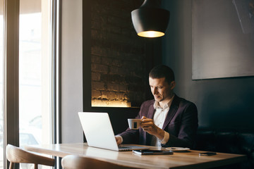 Young handsome businessman conducting negotiations with investors. Electronic business. Alternative...