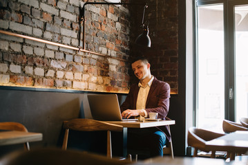 Young man drawing template for the web site associated with digital marketing, current trends and tendencies of UX / UI design. Businessman who rules his company remotely, like a freelancer