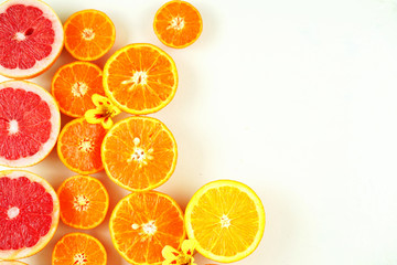 Colorful citrus fruit including blood grapefruit, mandarins, oranges, lemons on white background with copy space.