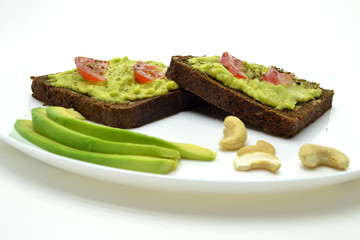 sandwich with avocado on a white plate nuts