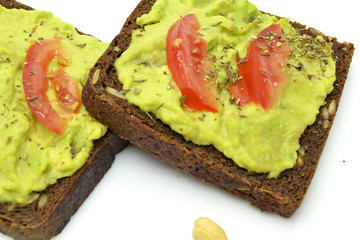 sandwich with avocado on a white plate nuts