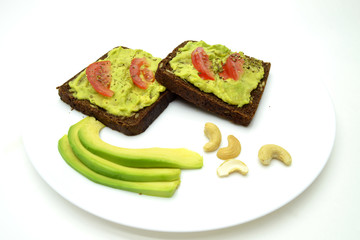 sandwich with avocado on a white plate nuts