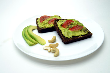 sandwich with avocado on a white plate nuts