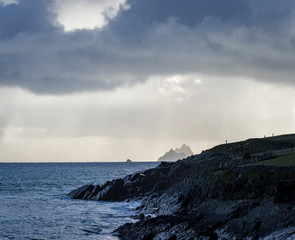 Fototapeta premium a view of the wild atlantic way off the coast of the ring of kerry in ireland showing skellig michael and surrounding islands in beautiful strong light with cloudy skies 