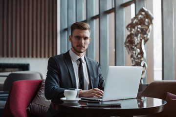 Young handsome businessman conducting negotiations with investors. Electronic business. Alternative...
