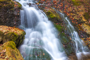 Fototapeta na wymiar Waterfall in a forest at autumn season. The Mala Fatra National Park, Slovakia, Europe.