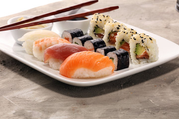 close up of sashimi sushi set with chopsticks and soy - sushi roll with salmon and sushi roll with smoked eel
