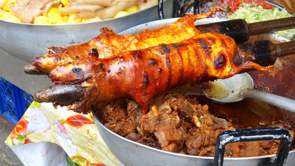 Traditional cuy (guinea pig) festival. Guinea pigs cooked on grill and ready for sale at the open market. Traditional food in Ecuador