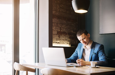 Stylish young man calling by the phone to solve business problems. Online consultation by phone. Freelancer discussing the development and planning of his online project. Outsourcing. Mobile services.