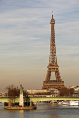 Paris, France - February 16, 2019: Liberty statue and Eiffel Tower near river seine in Paris