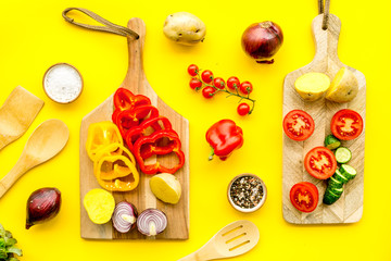 Fresh food ingredients for vegetarian kitchen on yellow background top view