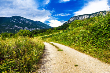 Mountain road and clouds on blue sky