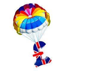 Pound of sterling symbol of British currency lifting by parachute on white background, isolated.