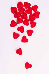 Concept of falling hearts made of heart shaped red jelly sweets on isolated white background. Top...