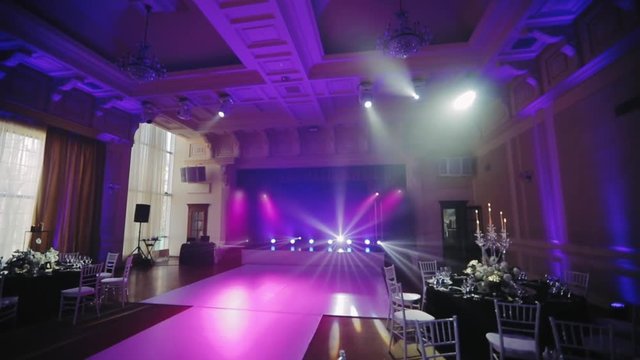 Luxury banquet hall decorated in black and white tones, wide angle camera shooting. Served table with a black tablecloth