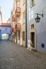 Naklejka premium Narrow street with an arch and old lanterns. Warsaw.