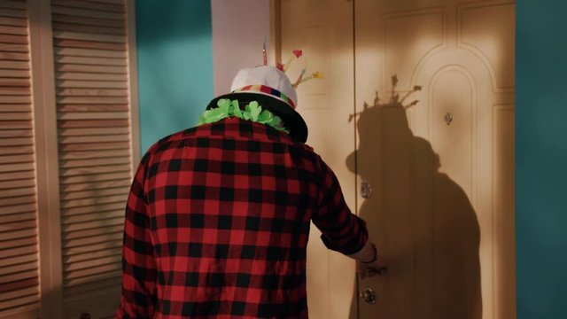 Funny drinker wearing B-day hat coming home after big party full of alcohol. Young man laying face down on bed. Alcohol problems.