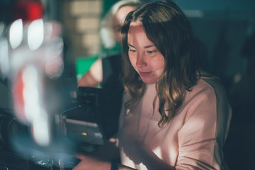 Girl cameraman behind camera on set