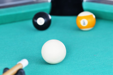 Playing Billiards on green table.  