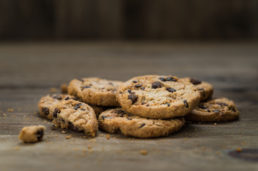 Classic chocolate chip cookies against wooden background. Concept of dessert, baking, and sweet food