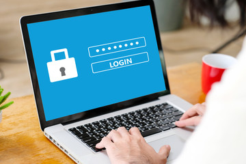 Hand tying laptop computer with password login on screen, cyber security concept
