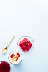Tiramisu with strawberry  in glass on a blue board, natural backlight